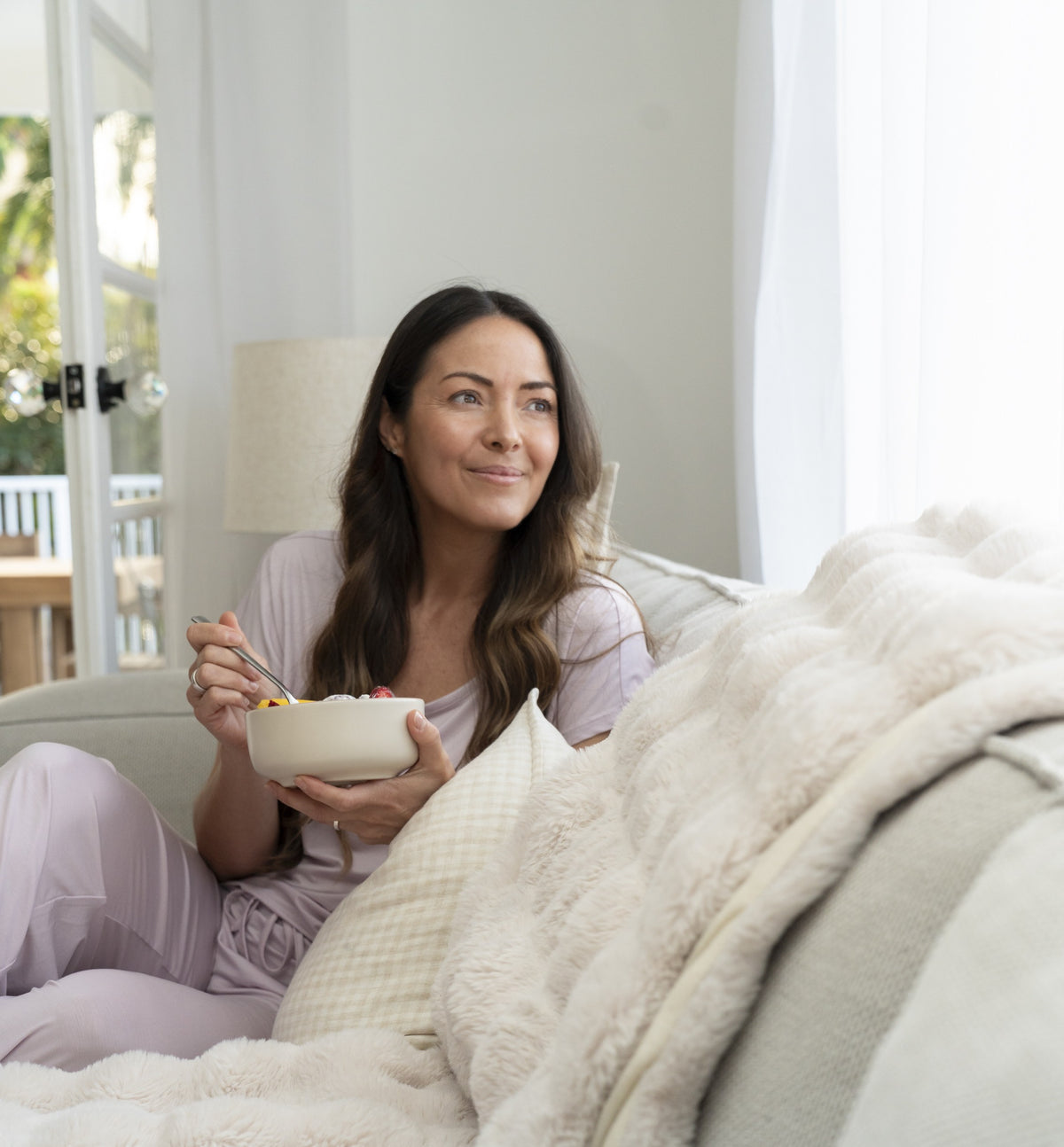 Woman sleeping comfortably in bed wearing lavender coloured sweat wicking lyocell pyjamas